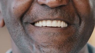 Close up male human lips healthy wide toothy white smile unrecognizable unknown wrinkled positive african american biracial senior man mature adult patient of dental orthodontic service talk at camera