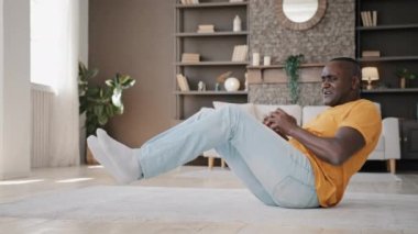 Active senior sportsman african american fit man lying on floor pumping up press muscle morning workout aerobics doing daily fitness exercise gymnastics with dumbbells healthy energy sport lifestyle