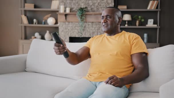 Orang Tua Bujangan Afrika Dewasa Amerika Yang Duduk Sofa Menonton — Stok Video