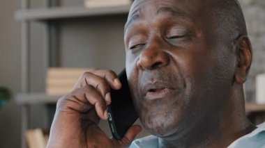 Erkek, kırışık suratlı, Afro-Amerikan, yaşlı, yetişkin, tüketici 50 'li yaşlarda iş adamı, cep telefonuyla konuşuyor.