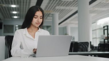 Meşgul, çekici, başarılı, Arap, İslami, genç, iş kadını, ofis çalışanı, iş arkadaşı, e-ticaret uygulaması kullanarak internette e-posta yazarak iş arkadaşı.