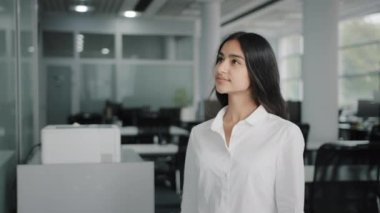 Düşünceli genç iş kadını Arap yaratıcı tasarımcı tahtaya gelip renkli çıkartmaları okuyup yapışkan kağıtların el yazısı listelerine hatırlatma yazıları yazacak kurumsal hedefler belirleyecek.