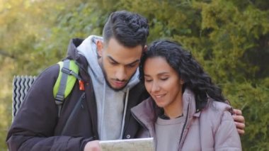 Yakın plan evli çiftler açık havada kağıt haritaya bakıyor yerel gezginleri araştırıyorlar sırt çantasıyla geziyorlar ve doğru yolu arıyorlar.