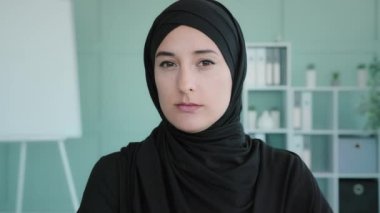 Portrait indoor sad upset offended oriental Muslim Islamic Arabian woman in headscarf black hijab confidently shaking head saying no disagreement not never wrong reject deny sign fail mistake reaction