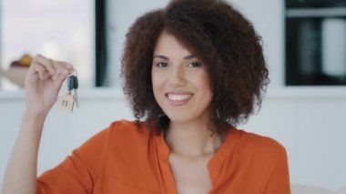 Portrait happy homeowner female buyer realtor African 30s woman with curly hairstyle showing key from own home real estate celebrate moving day relocation in new apartment property success investment