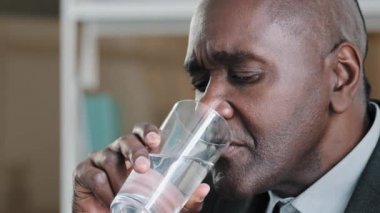 Afrika kökenli yaşlı yetişkin iş adamı artı lider işçi taze soğuk, durgun sıvı hidrat içeceği içerek gençleşme enerjisi sağlık hizmetleri alışkanlıklarını durdurur.