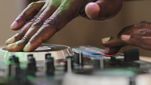 Close-up unrecognizable DJ man African skin male hands playing live electronic music on party in club spinning record vinyl twist disc using mixer controller desk make bit with fingers recording song