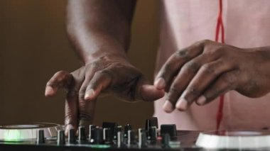 Close-up Dj mixer controller desk in club musician studio home disco party old African male hands touching buttons sliders unrecognizable dancing man playing electronic music techno sound audio live