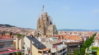 Arial view drone shooting houses civilian apartments in Barcelona cathedral temple La Sagrada Familia in town church historical building in Spain religious Catholic architectural masterpiece of Gaudi