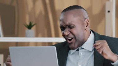 Close up portrait happy carefree funny African American businessman mature man boss leader old 60s worker dancing in office listen music singing song receive good news offer celebrate online victory