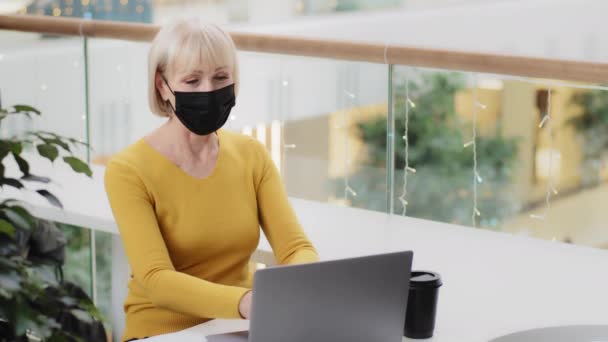 Elderly Woman Protective Mask Sits Desk Typing Laptop Playful Excited — Video Stock