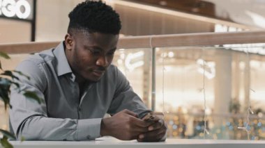 Focused young businessman answering business message send email on mobile phone handsome happy guy communicates in online chat writes sms checks social network using smartphone makes order on internet