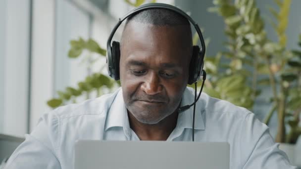 Concentrated African American Senior Entrepreneur Businessman Freelance Worker Wears Headphones — Vídeo de Stock