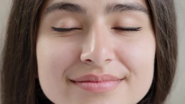 Close up human young female face sensual 20s generation arabian girl beautiful model glamour lady with closed eyes opening eyelids enjoying good eyesight in dark lenses after ophthalmology procedure