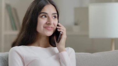 Hispanic lady has mobile conversation friendly chatter at home cellular chatting talking with friend boyfriend arabic young girl woman flirting by telephone gadget gossiping share good positive news