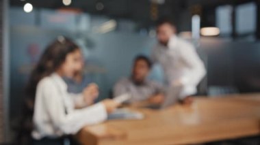 Blurred multiracial employees brainstorming in office working process colleagues browsing report documents discuss co-working corporate task business partners workplace successful interaction workers