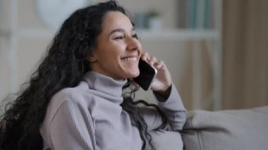 Portrait joyful young woman resting at home talking on telephone excited hispanic girl enjoy nice friendly chat share good news smiling millennial lady using modern gadget remote communication concept
