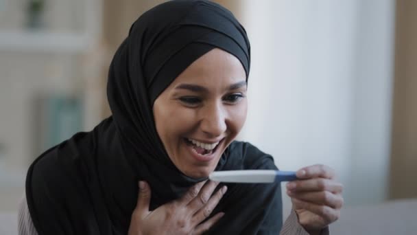 Радісна Ісламська Молода Жінка Хіджабі Посміхається Щасливо Тримаючи Тест Вагітність — стокове відео