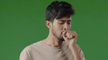 Portrait of sick sad arabic young man unhealthy guy suffering from cough sore throat covering mouth with hand first symptoms of cold health problems bad feeling illness outbreak flu virus coronavirus