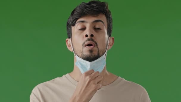 Tired Young Hispanic Man Medical Mask Green Background Studio Arab — Stock Video