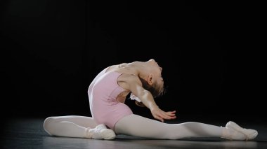 15s girl dancer ballerina teenager gymnast acrobat doing back bend position dancing element stretching exercises athletic child lady flexible dancer practicing gymnastics pose on floor bending body
