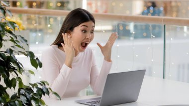 Korean Asian happy woman with laptop excited surprised scream yelling got university scholarship win online auction victory winning emotion female winner celebrate triumph scream with joy achievement