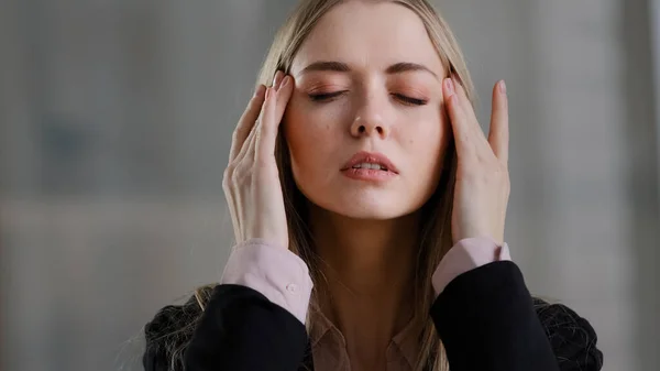 Tired exhausted ill sick business woman girl holding head headache fever feels unwell ache pain suffers from fever fatigue bad pressure massages forehead health problems pressure stress trouble. High