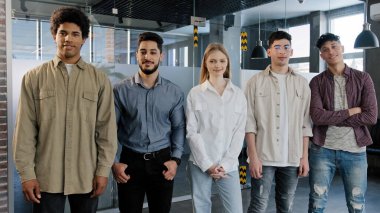 Genç ve mutlu çalışanlar sırayla kameraya bakıyor. Çeşitli meslektaşlarına gülümsüyor. Ofiste kendine güvenen beş profesyonel iş adamı.