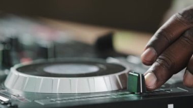 Close-up unrecognizable DJ man African American male finger using mixer controller desk in club switch audio disc turns up volume guy musician in studio play live music disco party touching sliders