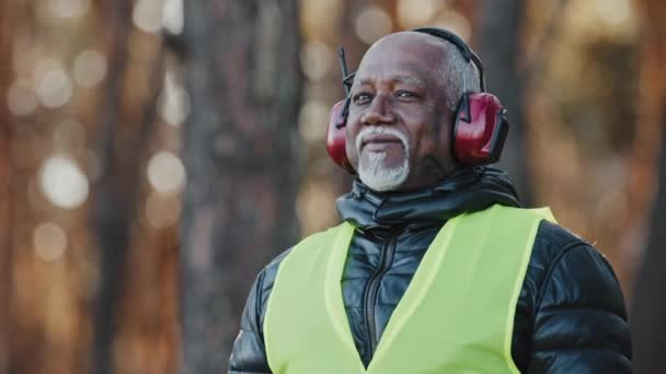 Пожилой Человек Профессиональный Лесной Инженер Защитных Звуконепроницаемых Наушниках Стоящих Лесу — стоковое видео
