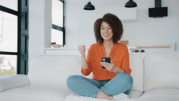 African American Woman Sitting Home Couch Looking Smartphone Using Phone — Vídeo de Stock