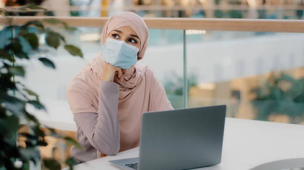 Pensive Young Muslim Woman Medical Mask Public Place Sitting Typing — стоковое фото