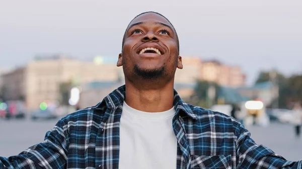 アフリカ系アメリカ人幸せな若い男でカジュアルTシャツで隔離された街の通り屋外でカメラを見てショックを受けた感情すごい手脳爆発ヘッドジェスチャーアイデアの問題概念を示す — ストック写真