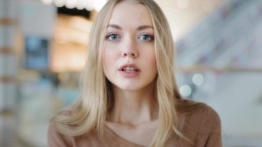 Close-up female face indoors portrait blond 20s girl millennial woman lady confused female looking at camera with interest searching someone listening attentively waiting puzzled expression emotions