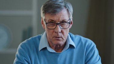 Close up shocked wrinkled male face old Caucasian businessman feeling amaze confused puzzled 60s pensioner take off eyeglasses looking at camera with interested expression listening unexpected news