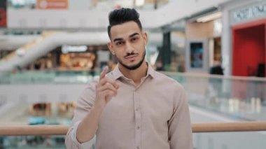 Hispanic Mexican Indian Arabian bearded man millennial 30s businessman shows direction forward with index fingers hey you are right gesture chooses agree choice choosing agreeing reaction great idea
