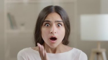 Emotional shocked brunette arab woman stressful frightened scared hispanic girl lady lost hold head with hands feel horror shock receive bad news awful surprise bankruptcy crisis negative information