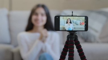 Mobile screen view of arab hispanic female blogger influencer woman girl record digital video on camera phone at home online broadcasting educational tutorial blog live vlog for popular social network