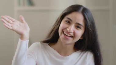 Smiling arabic hispanic blogger pretty girl female influencer student adviser woman actress recording video for acting in new film waving hand greeting online friend broadcasting vlog blog webcam view