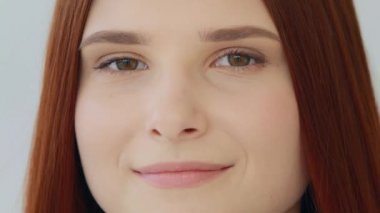 Portrait gorgeous beautiful red-haired young girl with flawless perfect face skin natural day makeup expressing friendly emotion good eyesight. Close up female body part of caucasian 20s student model