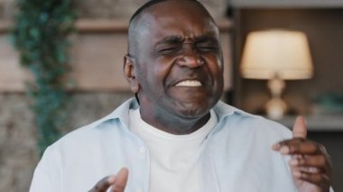 African artistic smiling man singer senior 50s funny musician vocalist bachelor singing jazz song american rap having fun at home musical performance listening track active gesturing in audio rhythm