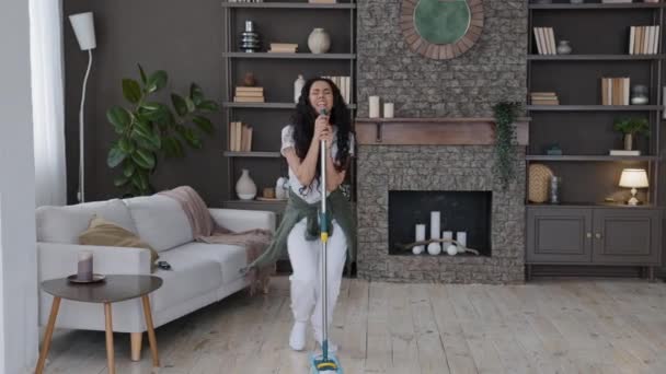 Happy Young Funny Woman Cleans Modern Living Room Singing Song — Vídeo de Stock