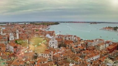 Aerial view of old historic city on banks wide water canal in Venice slow motion medieval italian town in sun rays noisy embankment busy port ships famous landmark famed tourist destination in italy