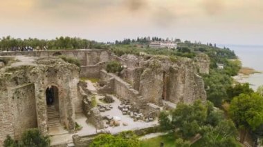 Aerial view historic island in Lake Garda Italy old historical town close-up archaeological site ruins Grotte di Catullo in Sirmione ideal tourist spot with castle on coast island italian attraction