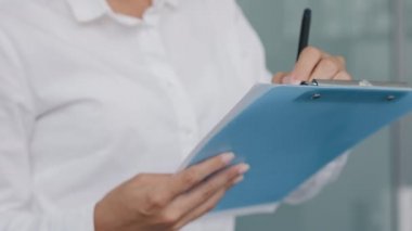 Close-up unrecognizable female secretary manager hold pen makes notes writes data in note tablet creates to-do list business ideas successful businesswoman planning workday for productive workflow