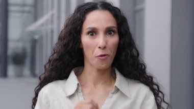 Amazed happy businesswoman win female face reaction good news. Excited overjoyed 30s emotional woman winner celebrating success looking at camera outdoors city outside shock surprise big eyes say wow