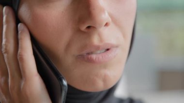 Close-up young unrecognizable arab woman in hijab talks on mobile phone confident businesswoman answering business call communicates with client remote using smartphone speaks with friend on telephone