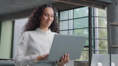Successful businesswoman working in modern office typing on laptop remote communicating with client developing project writes email message young attractive woman employee company works on internet