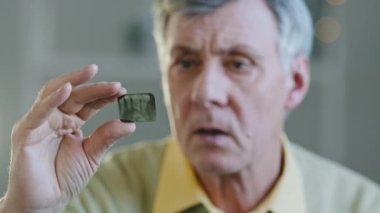 Close up sad Caucasian old senior mature man indoor patient with toothy ache pain sick male holding teeth x-ray 3d image dentistry healthcare medicine dentist problem damage crack inflammation of gums