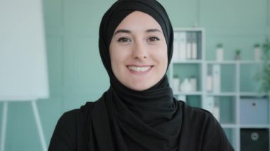 Close up moving shooting Islamic Muslim woman smiling toothy in office carefree businesswoman female boss leader student girl manager entrepreneur in company space looking camera with smile headshot